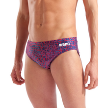 Load image into Gallery viewer, Person wearing a patterned swim brief with Arena branding on a white background