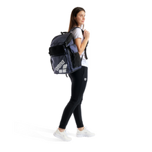 Load image into Gallery viewer, Person wearing a navy backpack with a brand logo on a white background