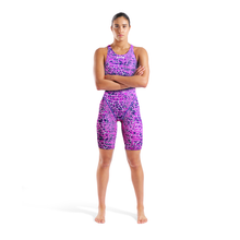 Load image into Gallery viewer, Full-length of a woman in an arena pink and purple snakeskin Powerskin ST NEXT racing suit