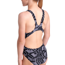 Load image into Gallery viewer, Girl wearing a black and white geometric patterned swimsuit on a white background
