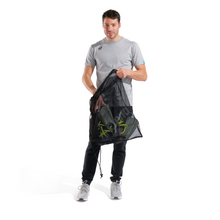Load image into Gallery viewer, Man holding a black mesh bag with swim equipment inside on a white background
