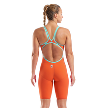 Load image into Gallery viewer, Woman wearing an orange and teal open back kneeskin racing suit 
